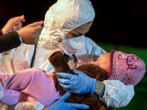 A rescuer cradled a toddler who was among 100 refugees, including 28 children, who were rescued near Sicily. Credit Alessandra Tarantino/Associated Press via New York Times